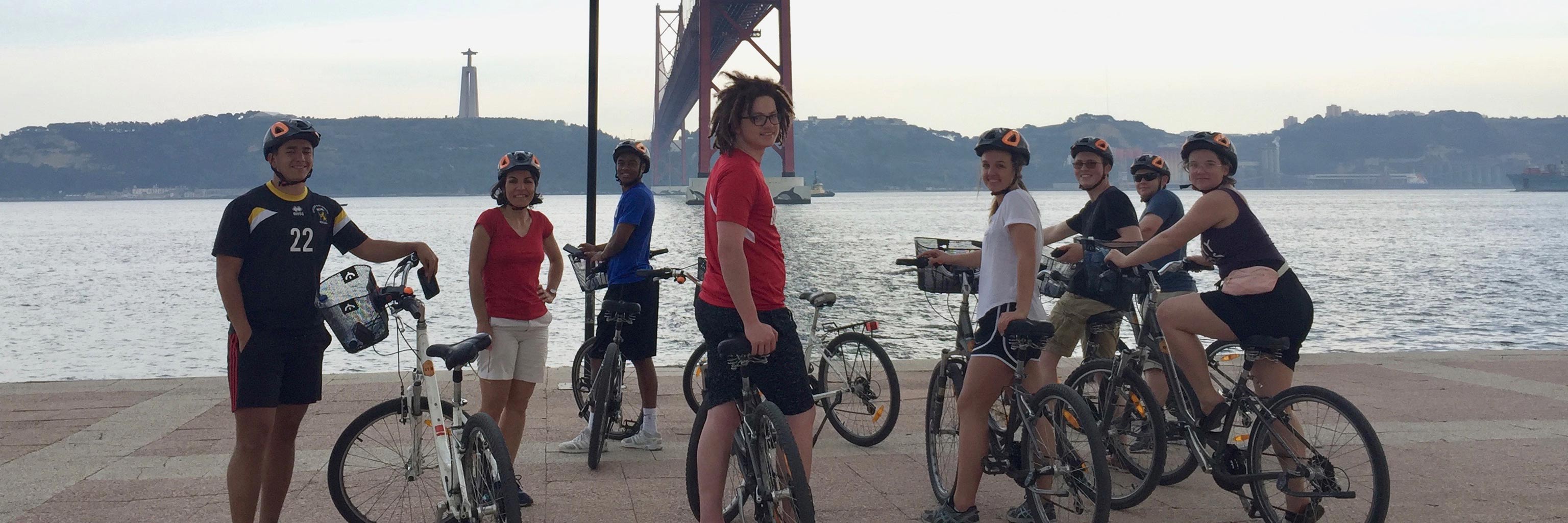 Students pose with their bikes on a waterfront 