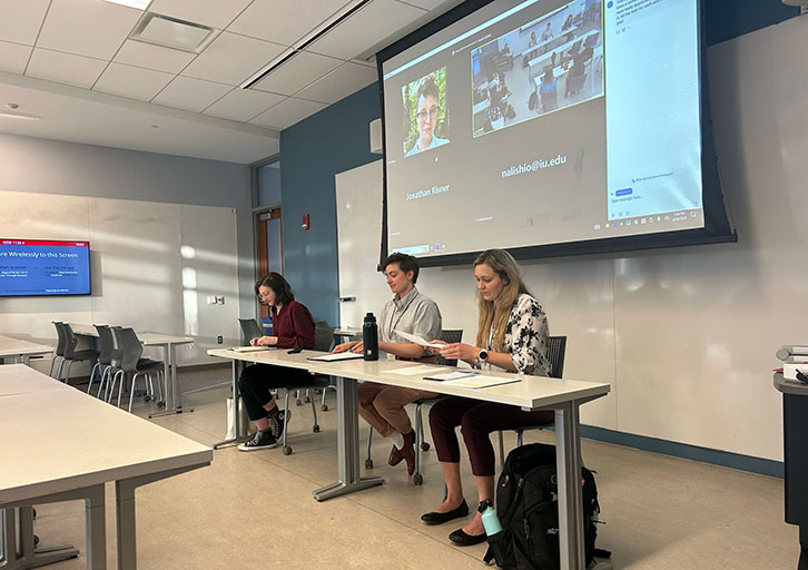 Three people present in a classroom.