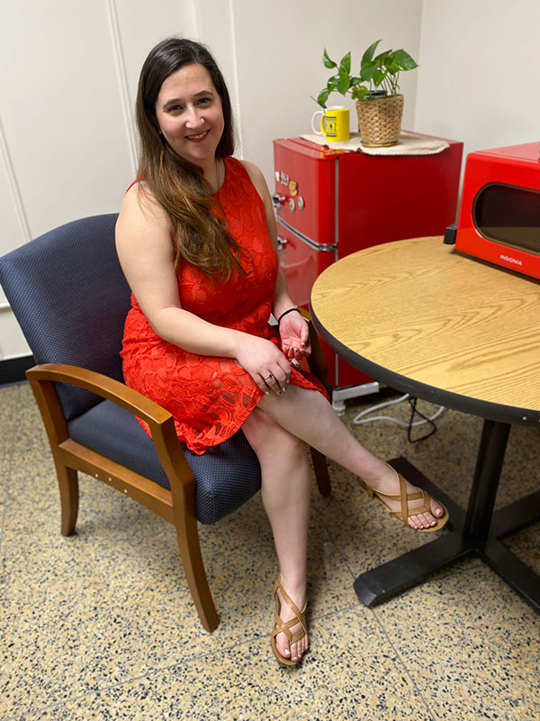 A photo of Gabriela Puscama, who is seated and wears a red dress.