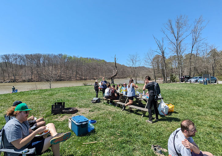 People sit together in a sunny field.